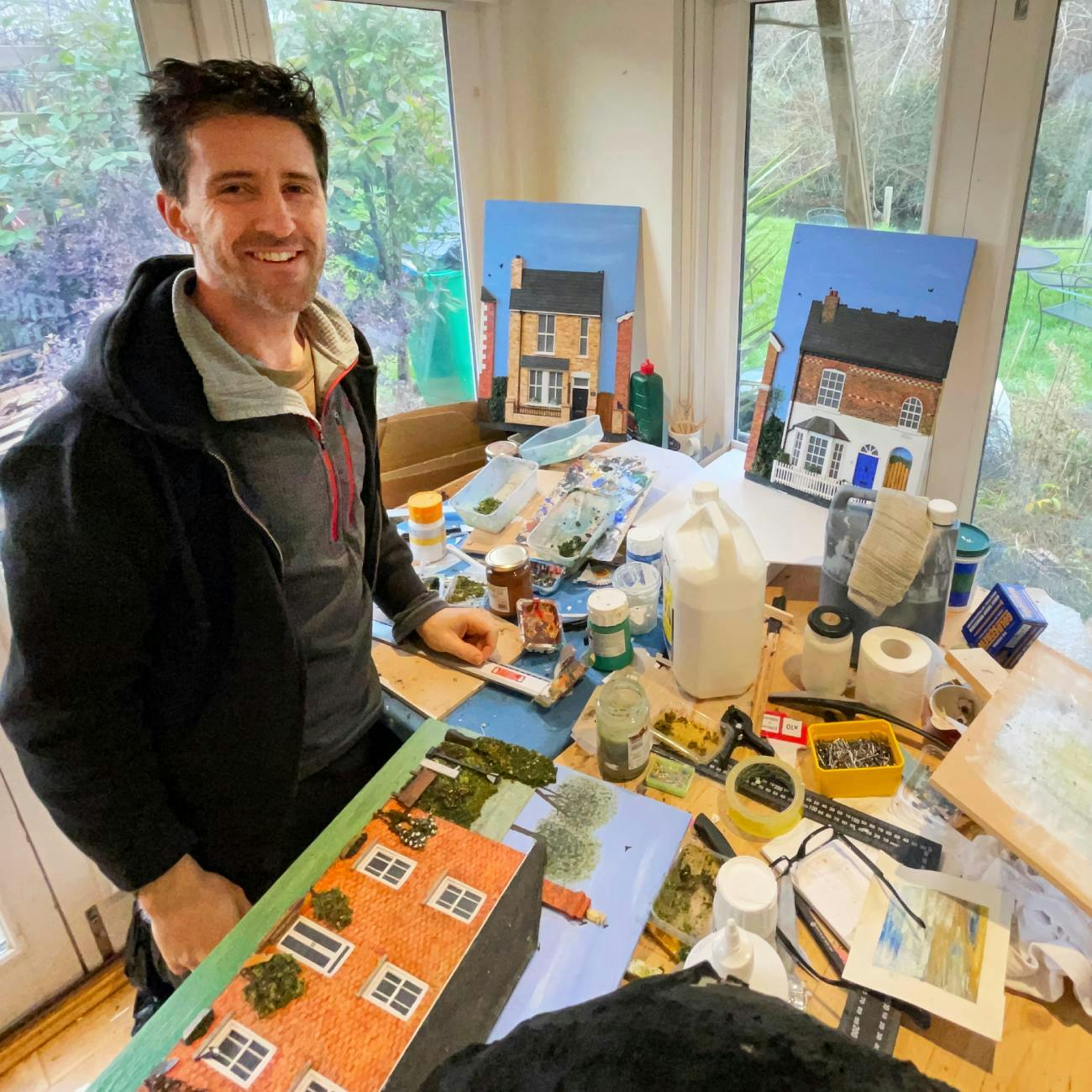 Patrick in his art studio with examples of his 3d, bespoke home paintings